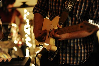 Closeup of a person playing guitar.