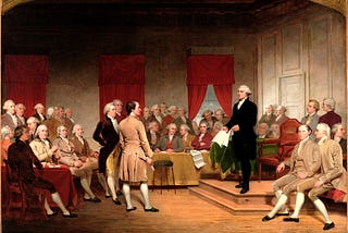 The painting “Washington as Statesman at the Constitutional Convention” by Junius Brutus Stearns depicts George Washington presiding over the 1787 Constitutional Convention in Philadelphia. Washington, dressed in black, stands on a raised platform, holding a draft of the proposed federal constitution as he urges its passage. Surrounding him are delegates in 18th-century attire, engaged in discussion, listening intently, or writing.