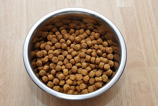 A bowl of dry brown dog food.