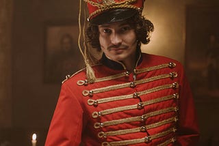 A handsome young man wears a vintage red British soldiers uniform