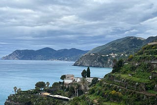 View of the Ligurian Sea and mountains from a high elevation in Manarola, Italy.