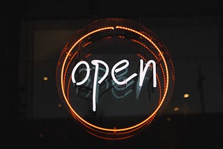 Light up sign with the word open in a circle.