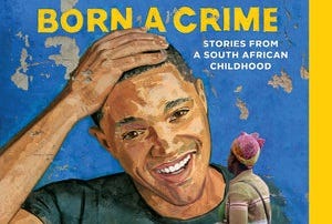 Trevor Noah’s face is painted on a wall with peeling paint. A woman stands facing it. The book title is painted above it.