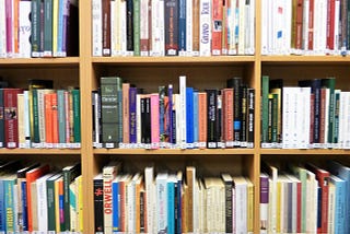 a bookshelf filled to the brim with books of all different colors, sizes, and genres