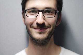 Man Smiling Behind Wall