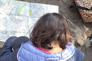 Young girl looking at Ordnance Survey map of the Peak District