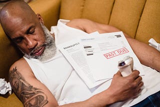 A man sleeping with unpaid bills on his chest