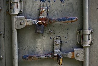 Padlocked arms on a rusty shipping container