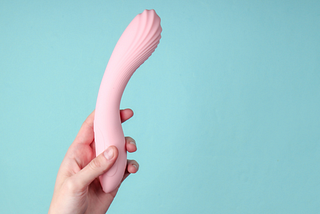 Woman in bedroom holding vibrator in hand — Ecsta Care