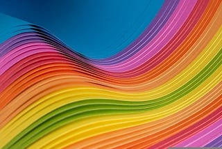 Photo of wavy layered sheets of paper(?) in rainbow colors