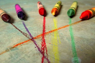 six crayons pointing forward, matched with lines in their colors