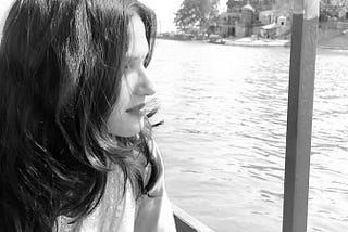 The writer of the story, Apeksha, is sitting in a boat which is in middle of the River Ganges. The writer is looking far away and pondering over her life.