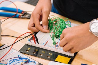 Hands connecting circuits on a circuit board