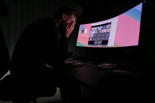 Matej Latin sitting behind his desk despairing with his head in his hands.