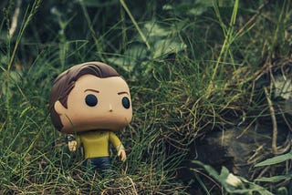 a close up of a Star Trek figurine in a field of grass