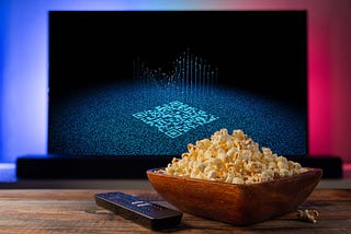 popcorn bowl in front of a TV with a QR code on the screen