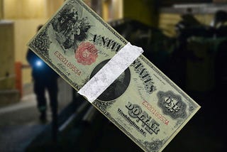 Taped 1917 dollar bill over blurred photo of night watchman.