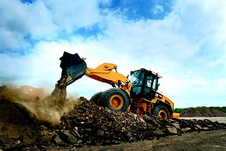 A cover image: an excavator on a pile of garbage.