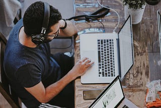 man working with headphones on computer