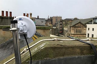 in the foreground a Wifi access point can be seen on top of a roof looking across a town