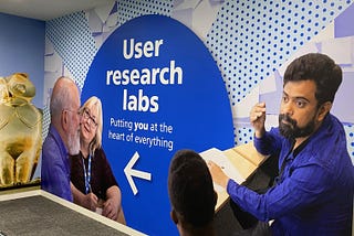 Mural outside the user research lab with 4 people around the words ‘user research labs. Putting you at the heart of everything’