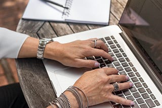 Woman’s hands placed on Mac Book Pro