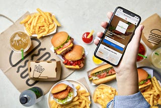 Spread of Shake Shack signature dishes with a mobile phone.