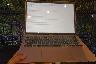 Hand holding Macbook Air during night time
