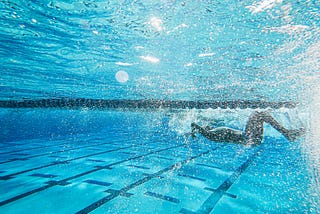 A woman in a black bikini swimming in a pool