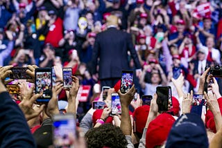 Trump rally at Grand Rapids in 2019 with many spectators holding their phones up to film Trump as he walks away.