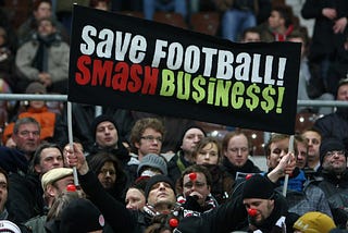 Fans of German football team St Pauli show their dismay at the influence of big business on football prior to a match against FC Kaiserslautern in Hamburg with a banner saying: “Save football! Smash Business!”