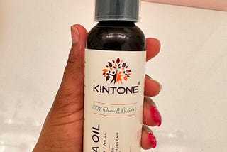 Customer holding a bottle of Kintone Batana Oil in her hand.