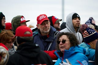 Diverse group of Trump supporters gathered outdoors on a chilly day.