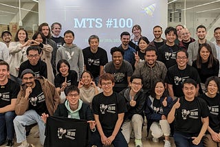 A group photo with several dozen people taken after MTS #100. Most are wearing the t-shirt made for the event.