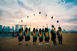 Image of college graduates throwing their graduation caps in the air