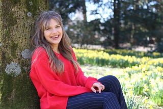 Smiling woman wearing a red sweater.