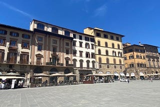 Businesses that align the Piazza della Signoria in Florence, Italy. Tents for eating outside can be seen in front of restaurants.