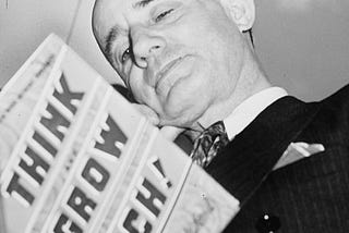 Napoleon Hill holding a copy of his book, “Think Grow Rich!”/Wikipedia.org