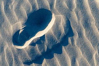 Photograph of a footprint in fine sand.