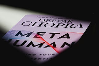 A light falls over the cover of Deepak Chopra’s 2019 Metahuman against a black background, which he wrote while he befriended and emailed Jeffrey Epstein.
