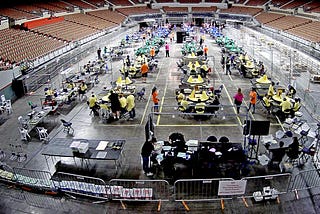 Tables and chairs with people and boxes of ballots, inside an auditorium during the Arizona audit, May 6, 2021.