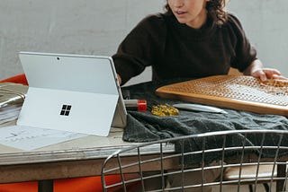 A person sitting at a desk looking at a windows surface pro