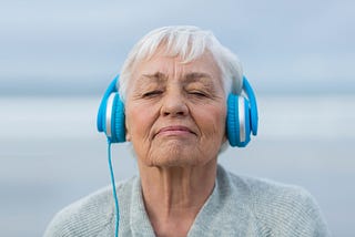 An older lady enjoying music on her headphones