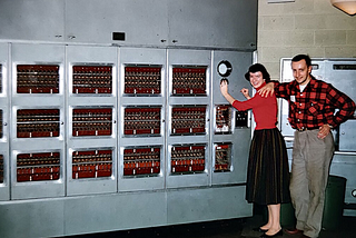 A huge wall of computing with a woman and a man smiling