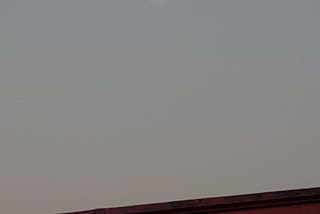 A picture of the full moon in an early morning gray sky.