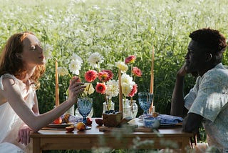 two people sitting at a table with a beautiful bouquet of flowers between them