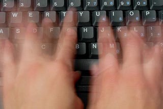 person typing furiously on keyboard