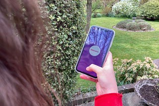 A person holding a mobile using the WelcoMe app outside