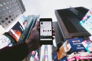 Person holding up phone, checking their Instagram profile