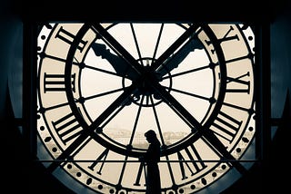 A woman is in front of an old clock